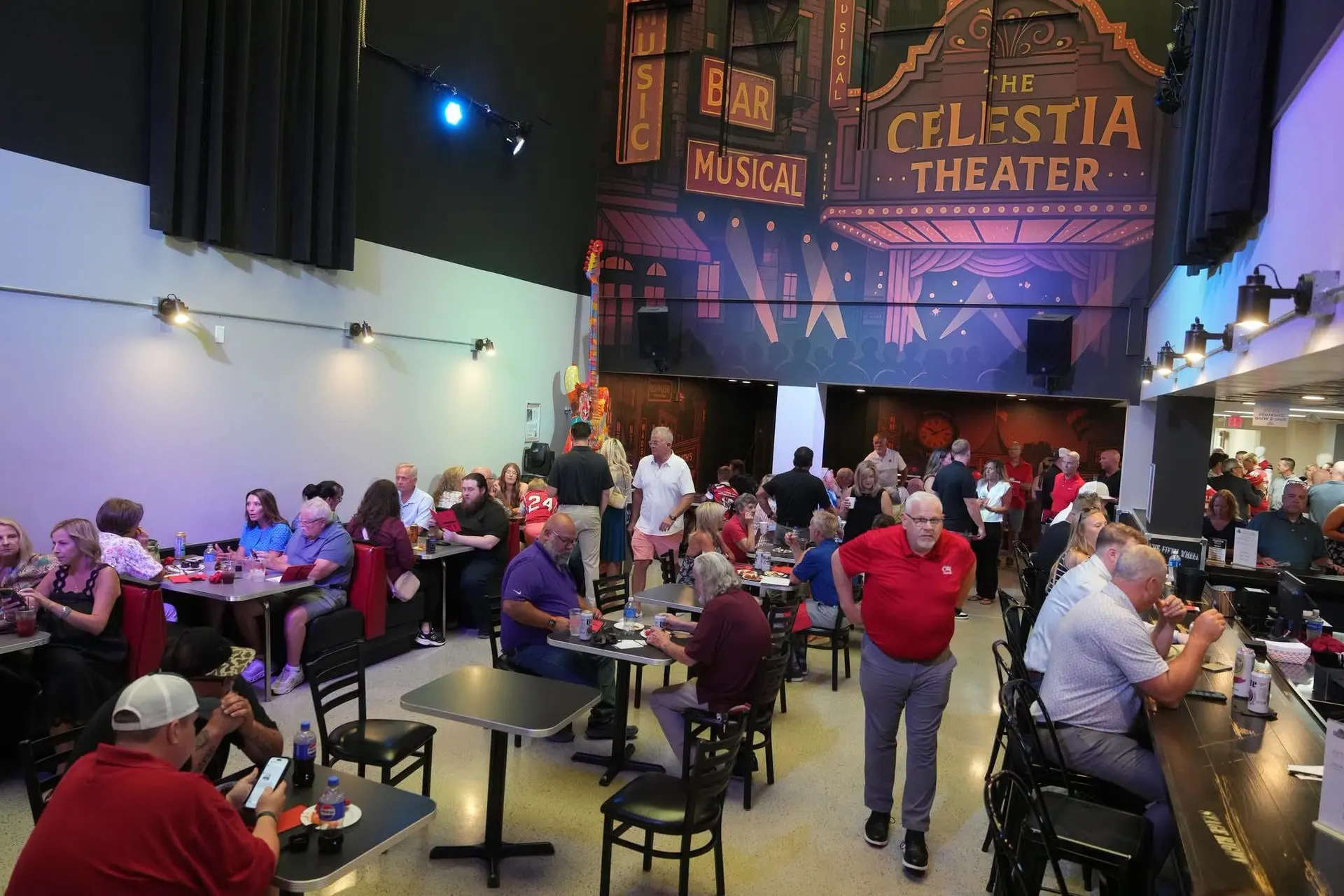 Flame Backstage Grille & Bar dining room on a show night, under the Celestia Theater marquee mural