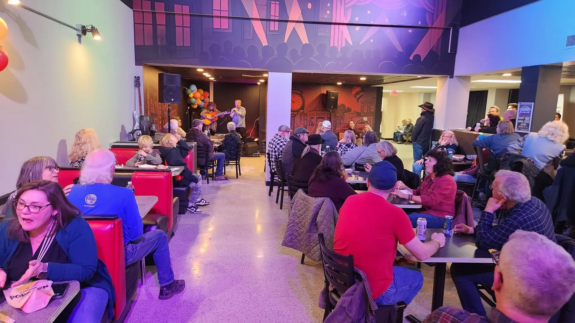 Live acoustic music at Flame, with the red booths and the downtown Wadsworth mural