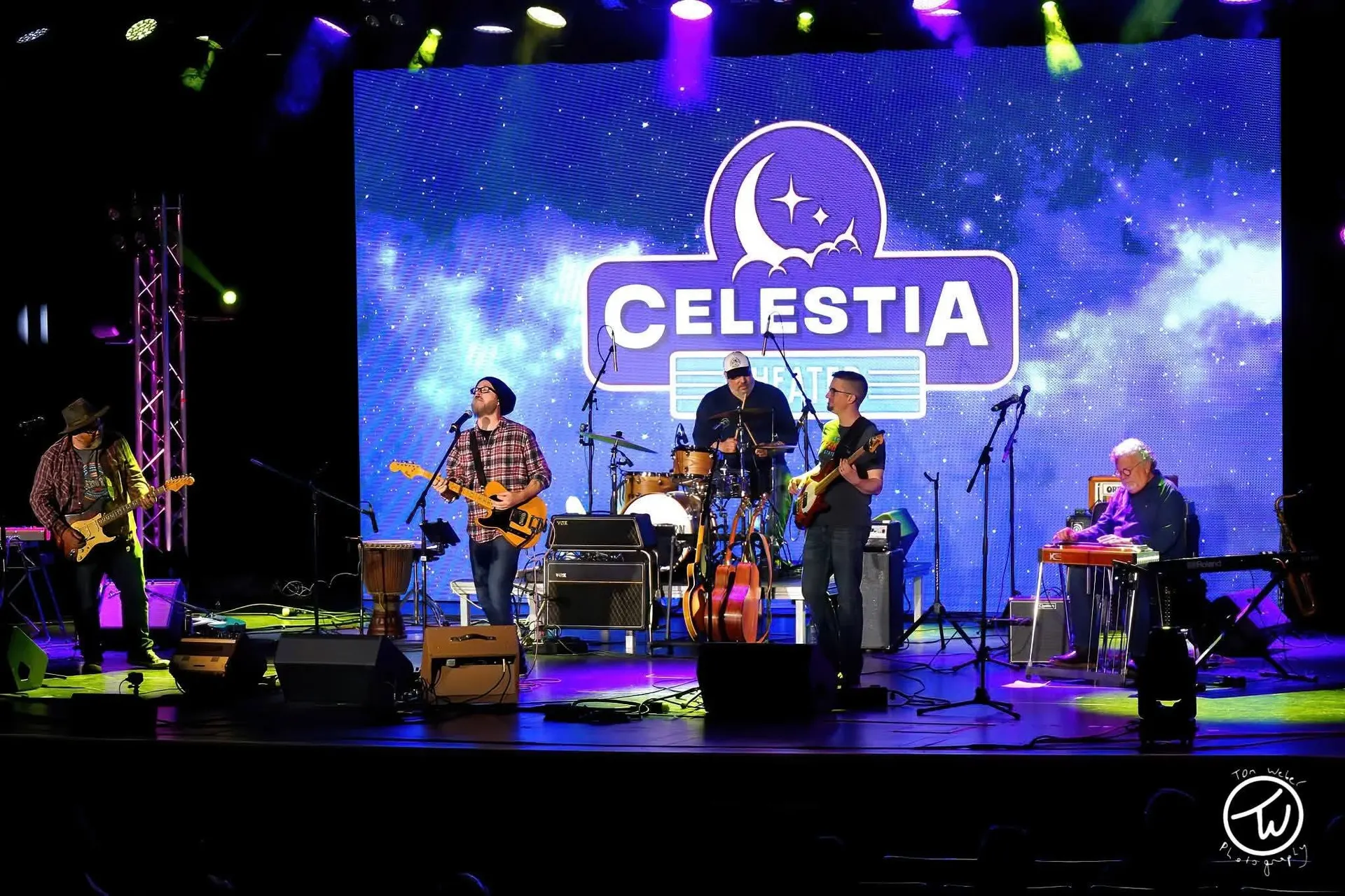 Band on the Celestia stage in front of the starfield LED wall with the theater logo