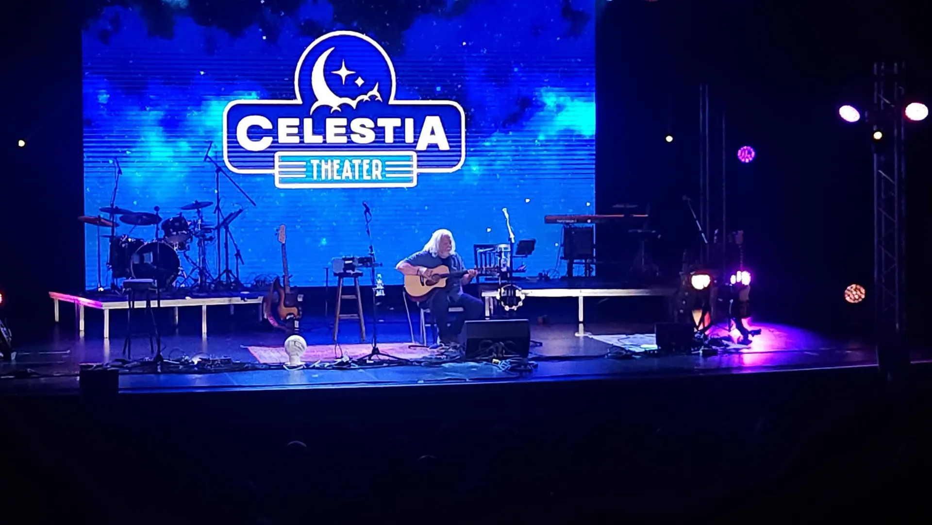 Solo acoustic performer with the Celestia Theater logo on the LED wall